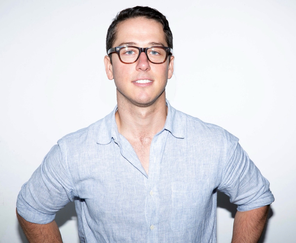 Andrew Rothaus, founder of Longsleeve, in a blue linen shirt against a white wall.
